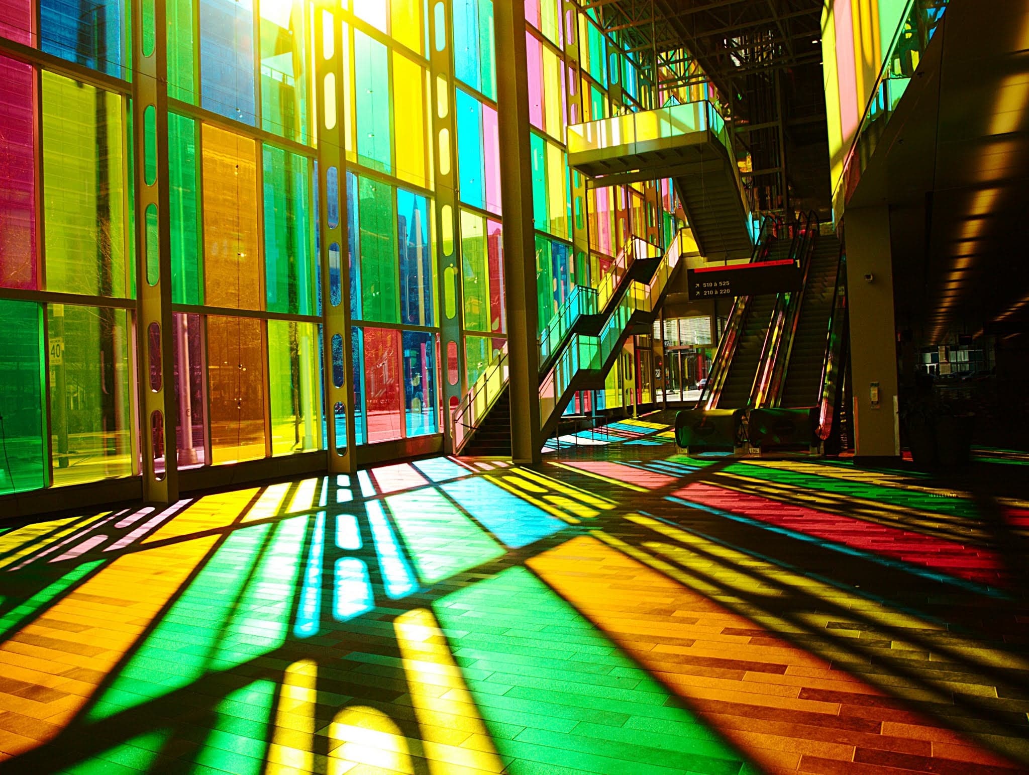Vibrant hues dance across the floor, as sunlight streams through multicolored glass, creating a kaleidoscope of shadows and light.